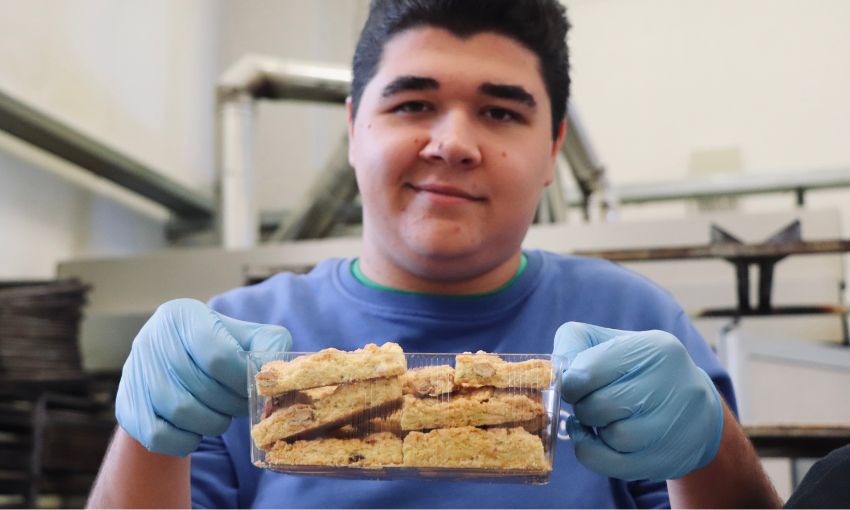ragazzo con una vaschetta piena di pezzi di sbrisolona