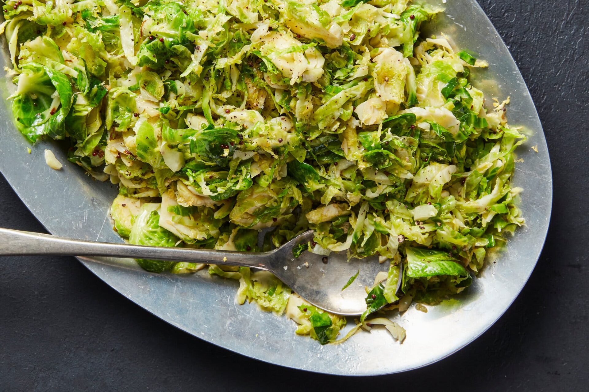 An overhead image of shredded brussels sprouts on a metal platter.