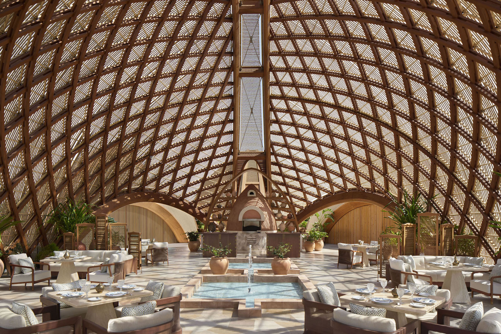 Una delle zone comuni del resort, coperta dalla grande cupola caratterizzata da elementi in legno curvato abilmente intersecati.