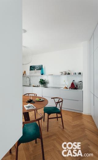 Nella composizione su disegno della cucina, realizzata da Sanca Arreda, il piano cottura in vetroceramica a induzione è di Bosch. Il tavolo da pranzo rotondo è il modello Acco, le sedie le Valerie, tutto di Miniforms. La lampada a sospensione è Spokes 2 di Foscarini.