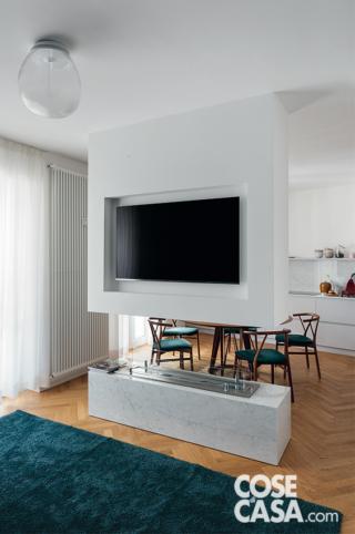 soggiorno, struttura centrale in cartongesso, camino a bioetanolo, nicchia con la tv, tappeto ottanio, lampada a soffitto, tendaggi bianchi