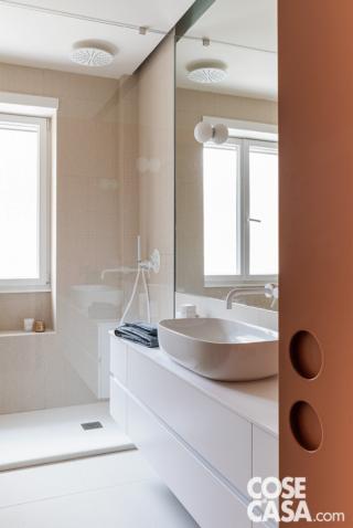 Nel bagno il rivestimento a terra e a parete è Pico Up Natural Banc; nel box doccia è Pico Red Dots Blanc, tutto di Mutina. La rubinetteria in bianco è della coll. Lino di Neve.