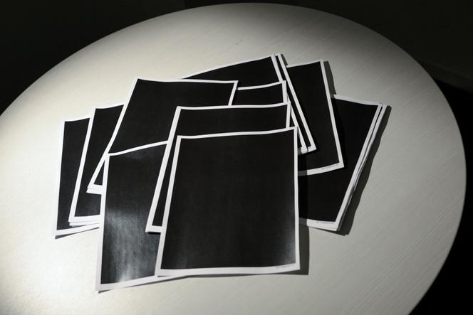 Une liasse de pages entièrement caviardées tirée des documents récemment publiés par le département de la justice américain du dossier Epstein, à Washington, le 19 décembre 2025.