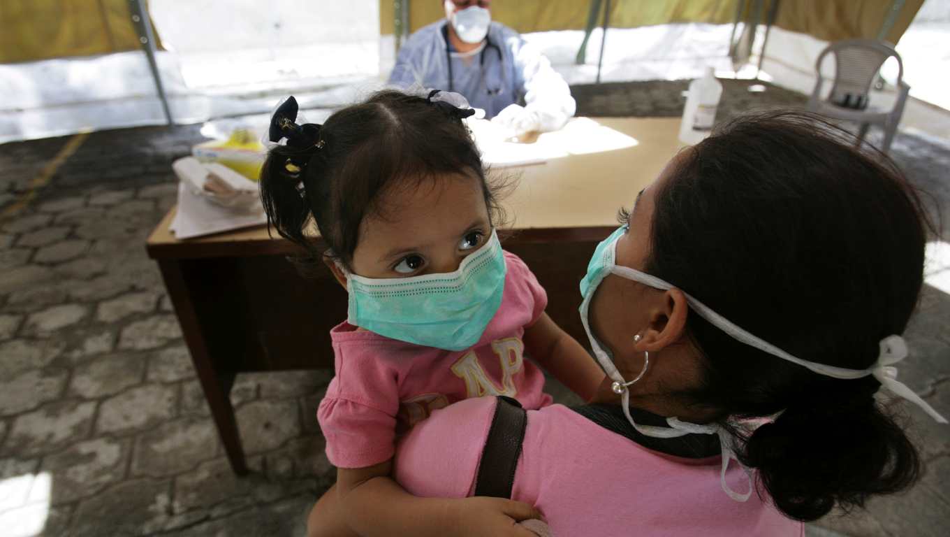 A doctor talks to a mother before testing her child for the influenza A (H1N1) virus at a mobile clinic in the Children's Hospital in Managua June 2, 2009.  Nicaragua's health authorities on Tuesday announced that the first case of H1N1 flu has been reported in Nicaragua.     REUTERS/Oswaldo Rivas (NICARAGUA HEALTH)