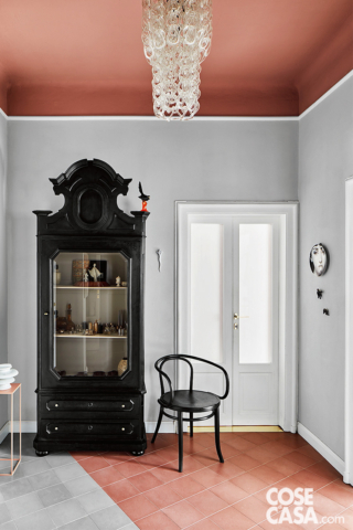 Angolo dell'ingresso con credenza d'epoca dipinta di nero e chandelier in vetro soffiato