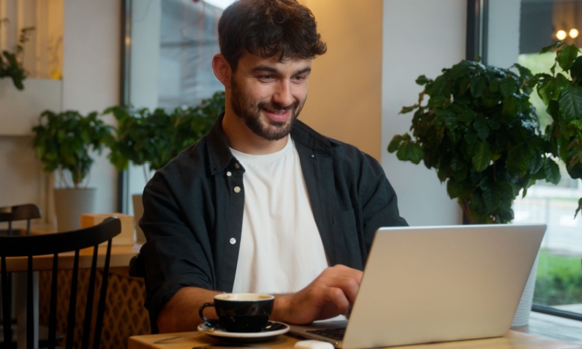 ragazzo al pc con una tazza di caffè